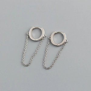 Detail of silver hoop earrings with clear cubic zirconia and long chain dangle pendant