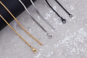 Vista dettagliata delle catene box punk in oro, argento e nero con chiusure a moschettone