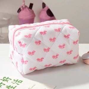 Détail de la trousse de maquillage matelassée à nœuds roses avec fermeture à glissière