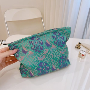 Detailed embroidery on vintage green jacquard cosmetic bag with floral patterns