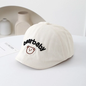 Vue détaillée du béret en coton crème avec broderie bearbaby et motif d'ours mignon