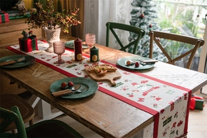 Detailed view of red cotton linen Christmas table runner with Merry Christmas lettering