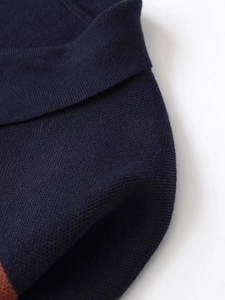 Close-up of navy blue striped polo knitwear showing dense flat knit texture and stitch quality