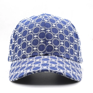 Dettaglio del cappello in denim blu navy con ricami circolari bianchi e trama in pizzo