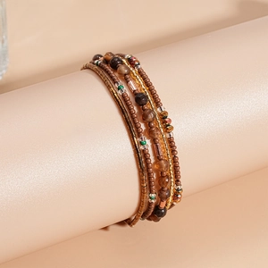 Macro-opname van een meerlaagse boho-armband met agaatkralen en bronzen details