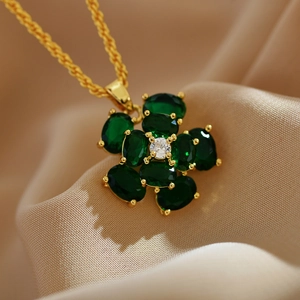 Macro shot of gold floral pendant with green malachite and white zircon detail