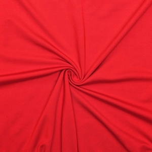 Detail of red knit fabric texture showing soft spiral drapes and material quality