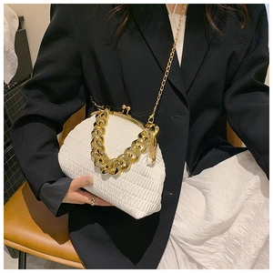 Detail of white quilted shell bag with chunky gold chain handle and metallic frame closure