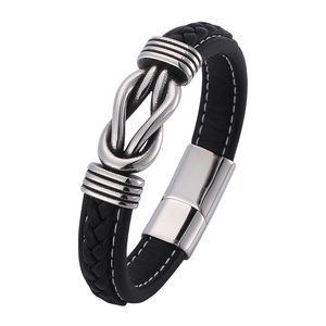Detail of black braided leather bracelet featuring a silver metal knot and magnetic clasp
