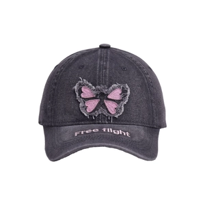 Detail of butterfly patchwork embroidery and Free Flight text on denim baseball cap