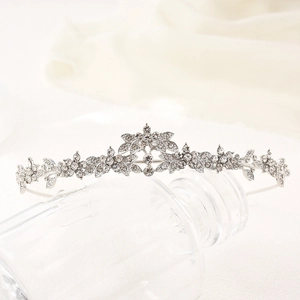 Elegant silver bridal tiara crown with rhinestones and floral alloy patterns on glass stand