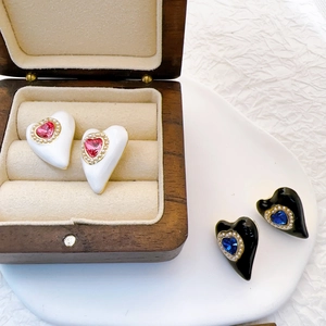 Detail view of heart-shaped earrings with faux gems and pearls in gift displays