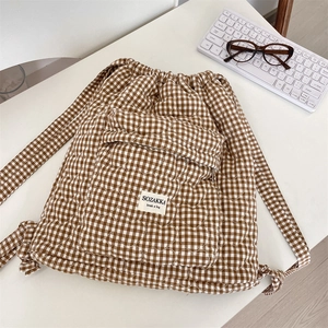 Detailed heart-shaped quilting and classic gingham pattern on a drawstring backpack
