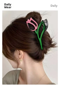 Detail of elegant pink tulip hair claw clip holding a bun hairstyle on model
