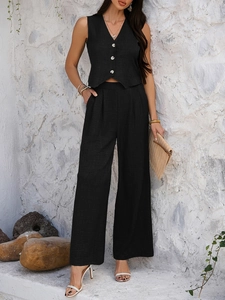 Detail of black V-neck buttoned vest and wide-leg trousers set with textured fabric