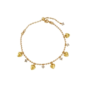 Elegant gold heart bracelet featuring sparkling cubic zirconia and beads on a white background