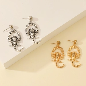 Close-up of gothic scorpion ear cuffs in gold and silver finish with crystal accents