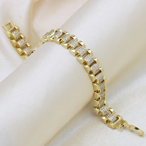 Dettaglio del bracciale stile cinturino in oro con zirconi brillanti su sfondo di seta