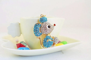 Detailed macro view of rhinestone-encrusted mouse keychain with blue and clear crystals