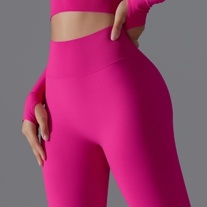 Close-up of hot pink high-waisted leggings and long sleeve yoga top with thumbholes