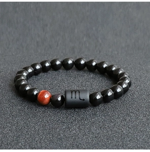 Detailed macro shot of Scorpio zodiac bracelet with black beads and red tiger eye stone