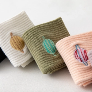 Embroidered planet crew socks in white, green, and pink colors with ribbed cotton texture