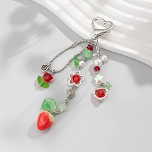 Détail du porte-clés fraise avec fermoir cœur, perles et breloques de fleurs rouges