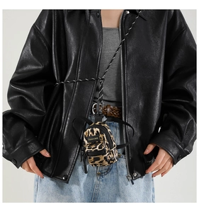Macro detail of leopard print mini bag with black zipper and fashion logo tag