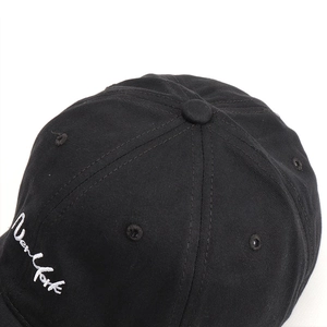 Close-up of white New York embroidery on a black cotton distressed baseball cap