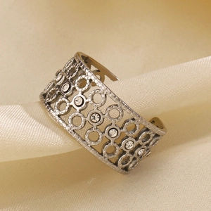 Polished silver stainless steel hollow ring with sparkling rhinestones on satin fabric