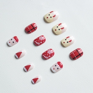 Detailed view of Christmas press-on nails featuring reindeer, Santa, and red plaid patterns