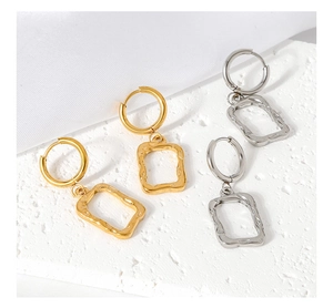 Close-up of gold and silver square geometric earrings with hammered texture details