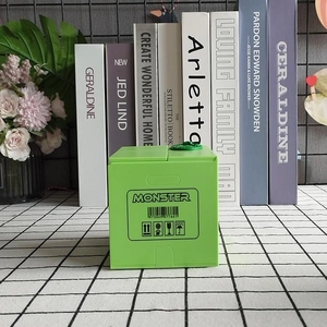 Close-up of a green electronic dinosaur piggy bank with Monster print and barcode detail