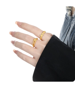 Macro view of gold irregular lava texture ring with sparkling diamonds on hand