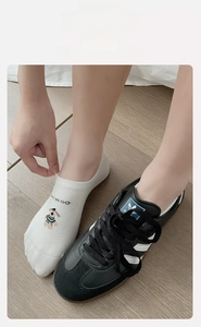 Detail of high-elasticity white cotton invisible sock with cartoon dog and text