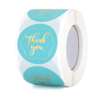 Macro detail of teal roll stickers with gold hexagonal frame and thank you script