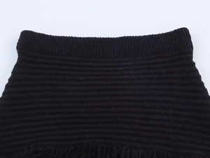 Dettaglio macro della trama in maglia nera con fascia elastica a costine in vita