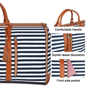 Detail of striped travel bag featuring comfortable handles and stylish tassel decoration