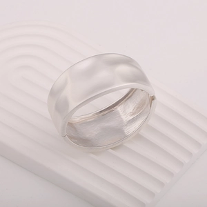 Detailed view of silver wide bangle featuring a textured hammered metal surface and hinge