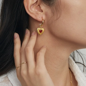 18k gold-plated stainless steel hoop earrings with red heart pendants on a model