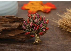 Macro detail of the tree brooch featuring red crystals and vintage bronze finish