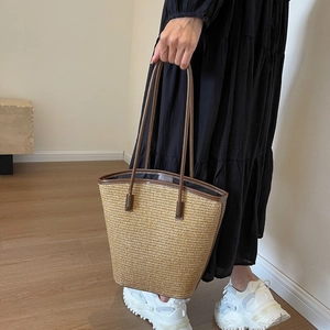 Fashionable striped straw woven tote bag with brown leather handles for beach vacation