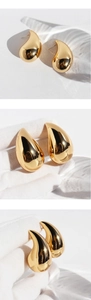 Macro shot of polished gold-plated teardrop earrings showing mirror-like metallic finish