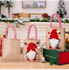 Three festive linen Christmas gift bags with gnome prints and striped handles
