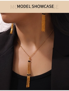 Detailed view of vintage gold multi-layer tassel necklace and earrings with black beads