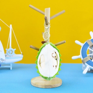 Cute durian plush toy keychain hanging on a wooden stand in a nautical themed setting