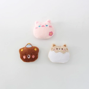 Close-up of cute plush animal pins with cat and bear embroidery for bag accessories