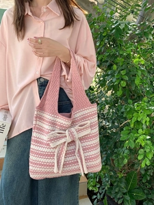 Macro detail of pink and white striped knit tote bag with large decorative bow accent