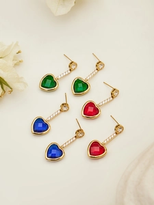 Detalle de pendientes de corazón en oro con piedras azules, verdes, rojas y diamantes
