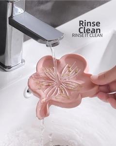 Pink plum-shaped silicone soap dish with self-draining spout showing easy rinse feature
